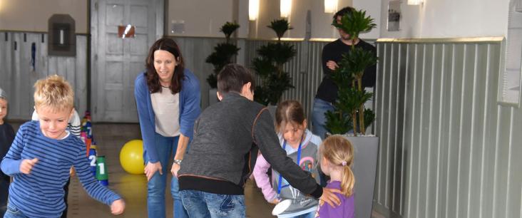 Erwachsene und im Flur herumrennende Kinder