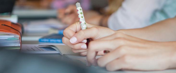 Schülerin, Schüler schreiben am Pult