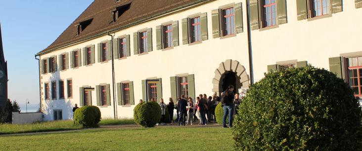 Menschen stehen vor dem Hochschulgebäude