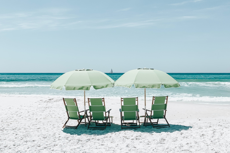 Strand mit vier Sonnenliegen und Sonnenschirm